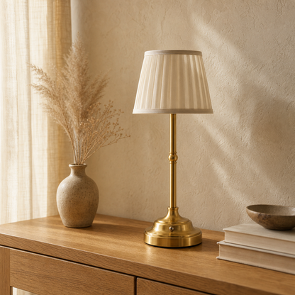 Gold Nordic rechargeable table lamp on a honeyed-oak console in soft daylight.
